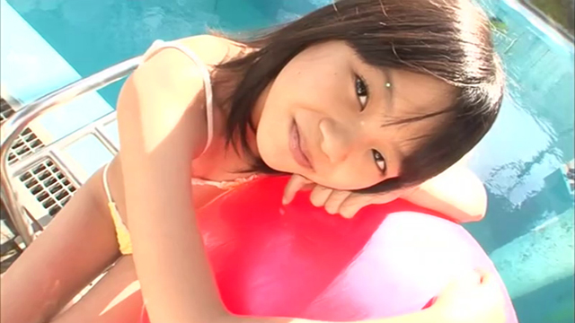 U12ジュニアアイドル宮田飛鳥ちゃんが黄色のビキ二姿でプールサイドでバランスボールに身体を預けてカメラ目線でポージングしている